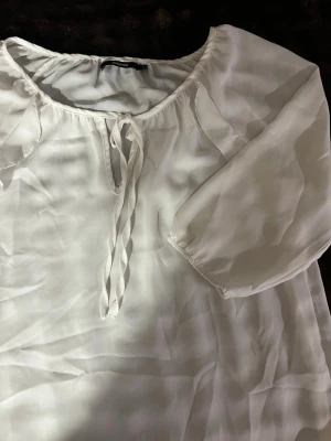 Blus  - En vit super fin blus med volanger och 3 kvarts ärm 