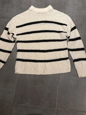 Vit stickad tröja med svarta ränder - Säljer en vit stickad tröja från 157 med svarta horisontella ränder. Bra skick. 