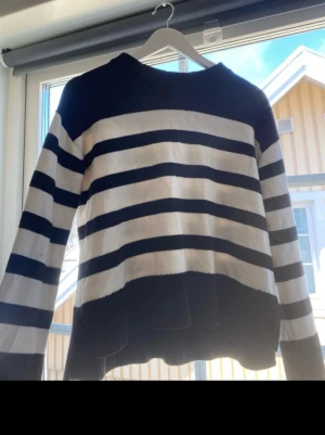 Randig stickad tröja i svart och vitt - Säljer en oversized stickad tröja med breda svarta och vita ränder. Stickad tröja, jätte fint mönster och material. Med en liten öppen slits vid varsin sida. Säljer utan av att den aldrig kommer till användning. Skulle säga att den sitter som Xs, fast jag köpte den från barnavdelningen🤍