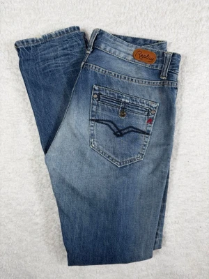 Blå Replay jeans  - Snygga blå jeans från Replay med fem knappar i gylfen och klassisk femficksdesign. Jeansen har en något tvättad look och raka ben. Bakfickan har en dekorativ söm och Replay-logga i läder baktill i midjan. Perfekta för en avslappnad stil.
