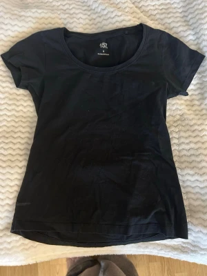 Svart t-shirt från 157 - En enkel svart t-shirt från 157 med rund halsringning och korta ärmar. Tillverkad i mjuk bomull med lite stretch för extra komfort. Perfekt basplagg att ha i garderoben.
