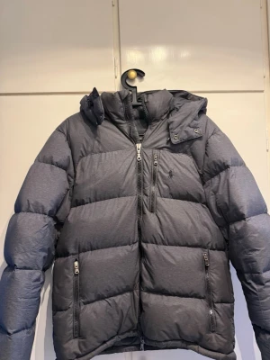 Mörkgrå pufferjacka från Polo Ralph Lauren - Säljer ett av mina favorit plagg pga den är för stor. Passar M/L. Jackan är i gott skick i sin helhet det enda som finns är ett hål på ärmen (se bild) och att en av dragkedjorna är utbytt (se bild), detta är inget som man tänker på utan jackan är i gott skick. Hör av er vid frågor