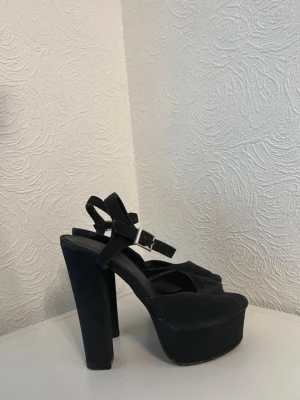 Svarta Nelly Klackskor - Fina höga snygga mockaimitation klackskor/ pumps från Nelly. Storlek 36. I okej använt skick. Sköna och stabila att gå i. Klackhöjd: 13cm Plattformhöjd: 4cm.