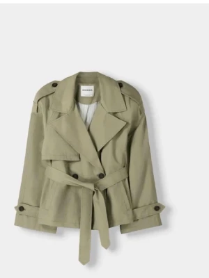 Grön trenchcoat från Bershka - Jättesnygg trenchcoat från bershka med band runt midjan. Perfekt nu till våren. Är i nyskick, endast använd två gånger. I storlek 36/s. Hör av er för bilder med den på!