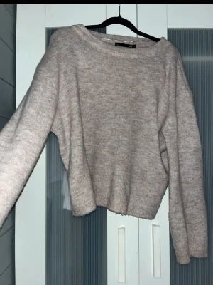 Beige stickad tröja från 157 - Mysig beige stickad tröja från 157 med avslappnad passform och rund halsringning. Tröjan har långa ärmar och ribbade muddar vid ärmslut och nederkant. Perfekt för lager på lager och enkel att matcha med jeans eller kjol.
