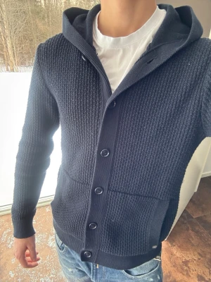 Mörkblå stickad hoodie med knappar - Skitsnygg och unik kofta/hoodie med knappar från Less Worries i storlek S i bra skick