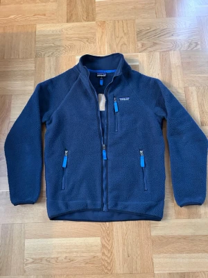Patagonia fleece tröja - Tjock tröja ifrån Patagonia i ett schysst återvunnet material. Tröjan är använd 5 gånger och där med har jag lappen kvar(den är bort klippt). Tröjan skickas även med Patagonia påsen. Tröjan är i storlek S men passar M också. 