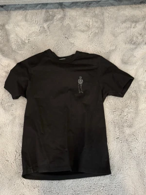 Svart C.P. Company t-shirt med tryck - Snygg svart t-shirt från C.P. Company med ett tryck på bröstet och ett större på ryggen. Klassisk passform, men med lite tjockare material. Ny pris 1300kr