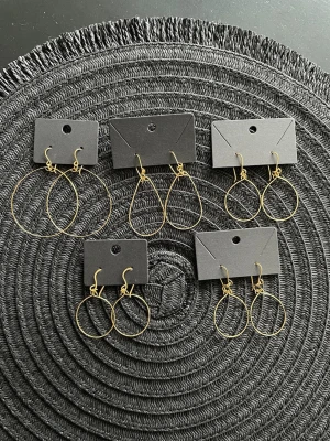 Fem par tunna guldiga örhängen - Säljer fem par stilrena örhängen i tunn guldfärgad metall. Alla har enkel, minimalistisk design med olika former som cirklar och droppar. Perfekta för dig som gillar diskreta men snygga accessoarer. Rostfritt mässing 