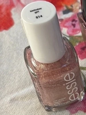 Essie Birthday Girl 514 nagellack - Glittrigt nagellack från Essie i nyansen Birthday Girl 514. Färgen är en skimrande rosa med massor av glitter som ger en festlig och lyxig känsla. Kommer i klassisk fyrkantig glasflaska med vit kork. Perfekt för dig som vill ha extra bling på naglarna.