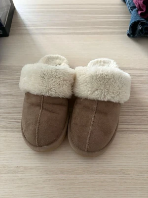 Innetofflor från Nelly - Innetofflor  med fluffig vit fuskpäls från Nelly som linkar uggs