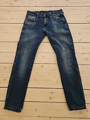 Ljusblå replay anbass - Snygga ljusblå jeans slim fit med riktigt fin tvättning. Klassisk femficksmodell med knappgylf och kontrastsömmar. Jeansen har en avslappnad passform och är tillverkade i denim, perfekt för en cool och enkel stil.