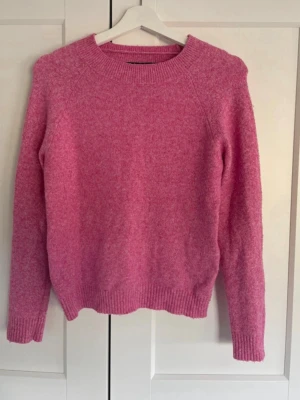 Rosa stickad tröja med rund hals - Mysig rosa stickad tröja med rund halsringning och långa ärmar. 