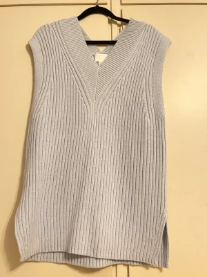 Ljusgrå ribbad stickad väst/tröja H&M - Köpt på H&M för cirka ett år sedan, men är aldrig använd eftersom den är för stor. Lappen finns kvar och den kostade 199kr Ha i åtanke att den är ganska stor trots att storleken är xs.