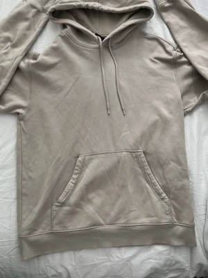 Beige hoodie från H&M Relaxed Fit - Snygg beige hoodie från H&M i relaxed fit med mjukt fleecefoder. Klassisk känguruficka framtill, ribbade muddar och justerbar huva med dragsko. Perfekt för chill dagar och enkel att matcha med jeans eller joggers. Hör av dig vid minsta lilla fundering o priset går självklart att diskutera😄