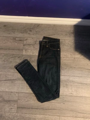 Mörkblå skinny jeans med smal passform - Snygga mörkblå skinny jeans med klassiska fem fickor och kontrastsömmar. Jeansen har en smal passform och normal midja, perfekta till en avslappnad stil. Tillverkade i stretchigt denim för extra komfort.