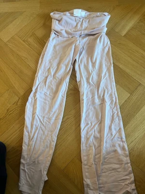 Ljusrosa leggings från Gina Tricot - Säljer ett par ljusrosa leggings från Gina Tricot med hög midja och stretchigt material. Perfekta att matcha med en oversized hoodie eller crop top. Mjuka och bekväma för en chill look.