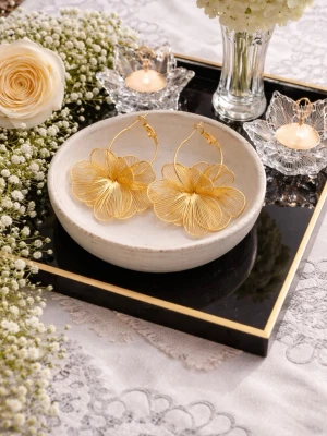 Guldiga blommiga örhängen i metall - Stora, statement örhängen i form av blommor med tunna, detaljerade blad i guldfärgad metall. De har en rund creolbas och är perfekta för dig som vill sticka ut med en unik accessoar. Ingen synlig branding.