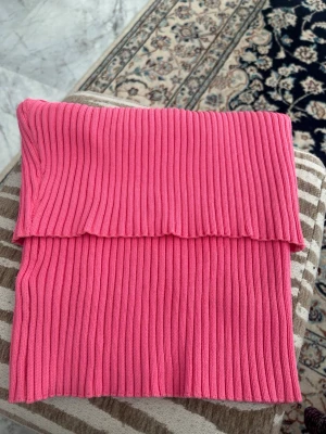 Rosa ribbad bandeau tubtopp strl M - Säljer en snygg rosa bandeau tubtopp i ribbat material. Toppen är ärmlös och har en croppad passform som sitter tight mot kroppen. Perfekt för dig som vill ha en enkel men trendig topp till sommaren.