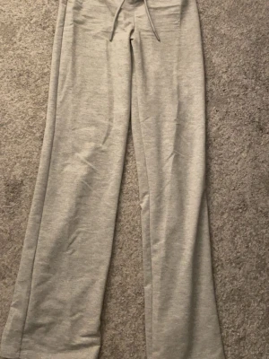 Grå mjukisbyxor från lager 157 - Ett par grå mjukisbyxor med raka ben och dragsko i midjan. Byxorna är tillverkade i ett mjukt och bekvämt material, perfekt för chill dagar. Enkel design utan synliga loggor eller mönster.