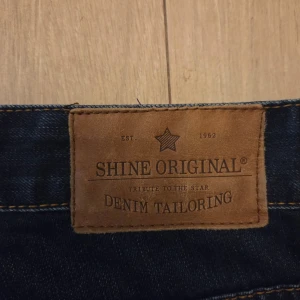 Mörkblå jeans från Shine Original - Snygga mörkblå jeans från Shine Original med klassisk denimdesign och kontrastsömmar. Märket är känt för sin industriella och danska stil. Perfekta för dig som vill ha ett stilrent och tidlöst plagg i garderoben.