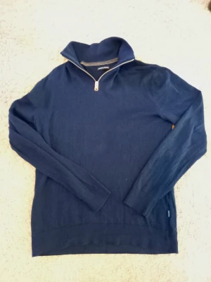 Jack and jones half zip - Snygg mörkblå stickad tröja från Morris med halvzip och hög krage. Tröjan har långa ärmar och ribbade muddar vid ärmslut och nederkant. Perfekt för lager på lager och stilrena outfits.