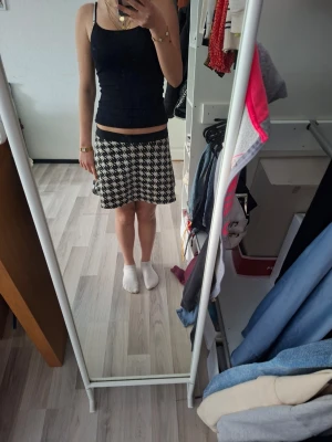 Svartvit rutig kortkjol - Snygg svartvit kortkjol med rutigt mönster. Kjolen har en lätt utsvängd form och sitter bekvämt i midjan. Perfekt för dig som gillar en klassisk men trendig stil. Använd några gånger.