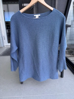 Blå ribbad tröja från H&M BASIC - En stilren blå tröja från H&M BASIC i ribbad bomullsblandning. Tröjan har rund halsringning och trekvartsärmar, perfekt för en avslappnad look. Enkel design som är lätt att matcha med olika outfits.