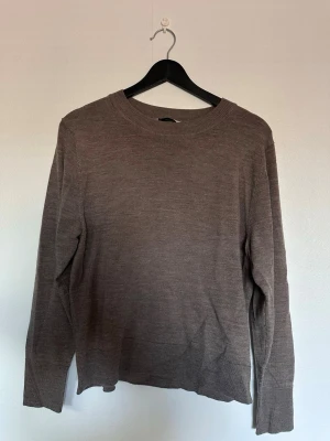 Brun merinoull tröja - En enkel och stilren brun stickad tröja i merinoull med rund hals och långa ärmar. Tröjan har ribbade muddar vid ärmslut och nederkant, perfekt för lager-på-lager och chill dagar. 