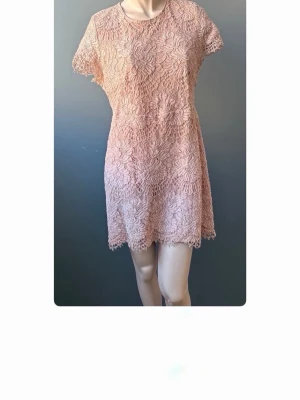 Spetsklänning med blommönster - Kort beige kl sturdy dig klänningsing från Y.A.S med vackert blommigt spetsmönster. Klänningen har rund halsringning sop korta ärmar och en sop öproppen rygg. Perfekt för sommarens alla tillfällen! Storlek XL men passar L. 