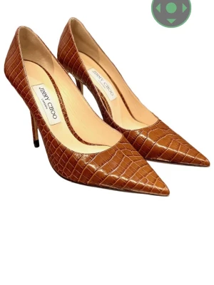 Bruna klackar i krokopräglat läder Jimmy Choo - Snygga bruna klackskor från Jimmy Choo i krokopräglat läder med spetsig tå och hög klack. Skorna har en elegant och tidlös design som verkligen sticker ut. Perfekta för dig som vill ha en lyxig och trendig look.