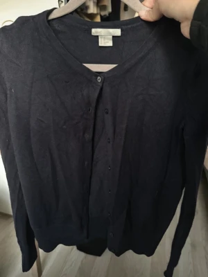 Mörkblå kofta från H&M BASIC - En stilren mörkblå kofta från H&M BASIC med knappar framtill och lång ärm. 