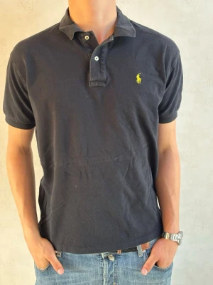 Svart pikétröja från Ralph Lauren  - Säljer nu en riktigt snygg piké tröja från ralph lauren, skicket är jätte bra och modellen på bilden är 184cm och väger 80kg. Bara att höra av dig vid minsta fundering!🤝