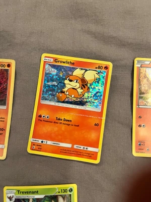 Pokémonkort Growlithe holo - Säljer ett holografiskt Pokémonkort med Growlithe. Kortet har en färgstark bakgrund i blått och orange, med gul ram och klassisk Pokémon-design. Perfekt för samlare eller dig som gillar Pokémon!