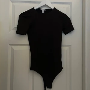 body - En enkel och stilren brun body med korta ärmar 