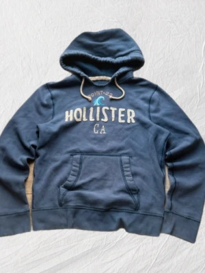 Hollister vintage hoodie S - Säljer en riktigt schysst blå vintage hollister hoodie i storleken L, tröjan sitter mer som S/M.✨ Tröjan har inga defekter - inga fläckar - inga hål - ingen dålig lukt ( kommer från djur och rökfritt hem🚭🐾) Tröjan är nyskick, då den knappt är använd✨🌟  Gåvor medföljer vid köp utan bud🎁💝  Tveka inte att ställa frågor vid minsta funderingar💬
