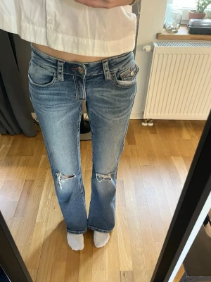 Gina Tricot low waisted jeans  - Low waisted jeans från Gina Tricot i mörkblå färg med detaljer på bakfickorna 🩷 Hål på knäna! Storlek 170. Knappt använda. Hör av er för fler bilder! 