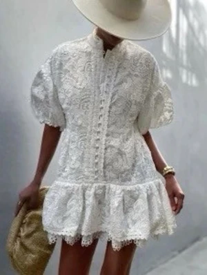 Vit spetsklänning med volang - Supersöt vit kortklänning i spets med puffärmar och volangkant nedtill. Klänningen har fina spetsdetaljer framtill och en avslappnad passform. Perfekt för sommarens alla tillfällen och ger en romantisk vibe.