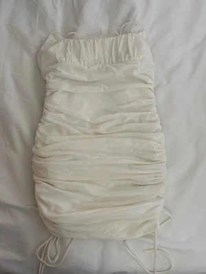 Vit klänning från nelly stl M - Vit klänning från Nelly🌸Köpt för några år sedan och har endast använt den en gång därav säljer jag!🌸Den är i storlek M men passar antagligen också S då den sitter väldigt tajt🌸