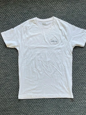 Handbroderad vit t-shirt från Denim Project - Handbroderad vit t-shirt från Denim Project. På bröstet finns en liten broderad text 'LUKE 1:37'. ”Inget är omöjligt för Gud.” Lite skrynklig runt broderingen