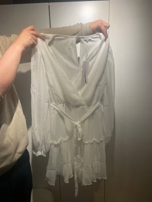 Vit omlottklänning med volang - En vit klänning från Bubbelroom direkt från paketet. Bara testad. En perfekt klänning till studenten samt andra roliga stunder!