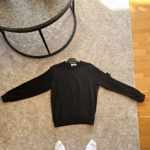 Svart sweatshirt från Stone Island - Säljer denna då den inte passar på mig  längre då jag har blivit större. det är en L men sitter som M på mig pris går att diskutera om.:)