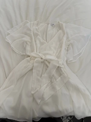 Vit omlottklänning med öppen axel - Jag säljer denna fina klänningen med snörning i midjan och öppna axlar ifrån bubbleroom🌸 den är i storlek 38🌸endast använd en gång!🌸