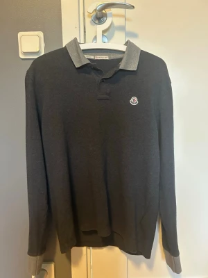 Mörkgrå Moncler pikétröja - Säljer en mörkgrå långärmad pikétröja från Moncler storlek S är knappt använd och är i bra skick                                                                                    Hör av dig vid minsta fundering✅
