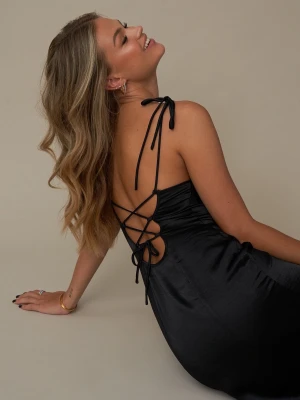 Svart satinklänning - Hanna Schönberg x NA-KD - Ny klänning utan prislapp. Köpte denna till ett tillfälle men valde en annan klänning. Elegant svart klänning i satin med smala axelband och snygg snörning i ryggen. Klänningen har en figurnära passform och en klassisk siluett som slutar under knäet. Vattenfalls ringning. 