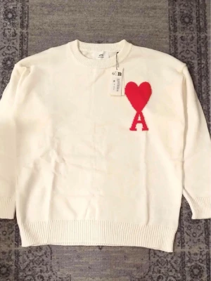 Vit stickad tröja Ami Paris hjärta - Säljer min jätte snygga tröja från Ami Paris, den är helt ny. Skriv vid frågor, priset är förhandlingsbart vid snabb affär och passar perfekt till kommande väder! Passar både män och kvinnor, kan dessutom skicka tröjan direkt efter köpet! 
