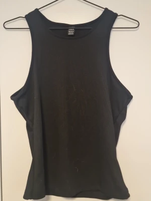 Svart ribbad linnetopp från Shein  - Snygg svart ribbad linnetopp från Shein med rund halsringning och ärmlös design. Perfekt att styla med jeans eller kjol för en clean och enkel look. Materialet är mjukt och stretchigt för skön passform.