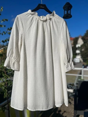 Vit kort klänning med volangärm - Vit klänning med volangdetaljer vid halsen och ärmsluten. Klänningen har trekvartsärmar. Underklänning finns så man ser inte igenom spetsen. Stl 38. Skickas eller hämtas på Hägerstensåsen eller ök 🤍✨