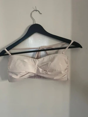 Ljusrosa bikini med knytning  - Säljer en ljusrosa bikini med twistad detalj framtill och smala axelband. Bikinitrosan har knyt i sidorna för justerbar passform. Perfekt för sommaren och strandhäng! Stretchiga och sköna, snygga och sitter bra på. Visar ej för mycket eller för lite. Sitter snyggt och bra på. Vecket på sista bilden är av att den legat i låda länge, går bort i tvätten igen, de är tvättade! Har bundle rabatter! Underdel i 36 och topp i 40. 