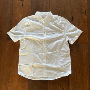 Kortärmad gant skjorta  - Säljer en klassisk vit skjorta från Gant med korta ärmar och knappar framtill. Aldrig använt. Perfekt inför sommaren. Vid frågor eller liknande kom dm😁